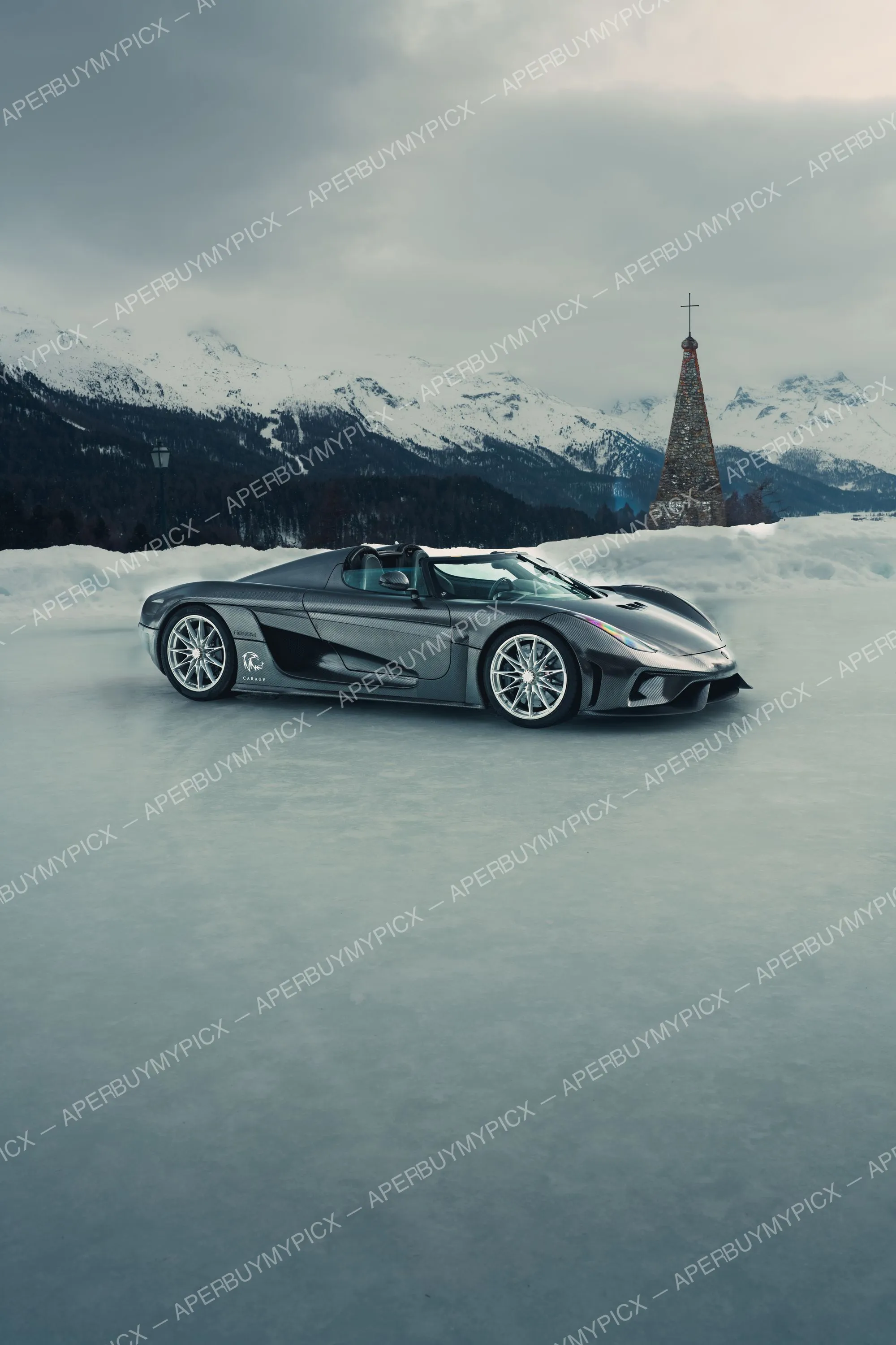 Koenigsegg Regera en fibre de carbone garée sur un lac gelé à St. Moritz, avec un clocher en pierre et des montagnes enneigées en arrière-plan sous un ciel gris.